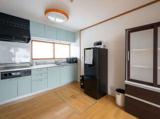 This charming kitchen boasts modern light teal cabinets, stainless steel countertops, and a built-in oven.