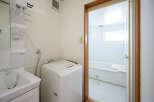 This cozy apartment features a combined laundry and bathroom area, complete with a washing machine and a bathtub.