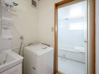 This cozy apartment features a combined laundry and bathroom area, complete with a washing machine and a bathtub.