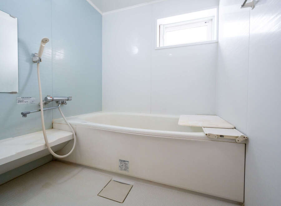 This charming bathroom boasts a clean and modern aesthetic, featuring a bathtub with a convenient built-in seat.
