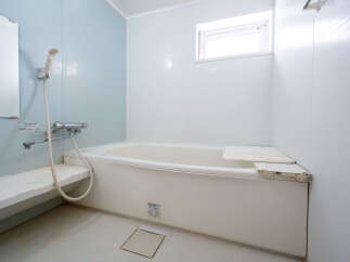 This charming bathroom boasts a clean and modern aesthetic, featuring a bathtub with a convenient built-in seat.