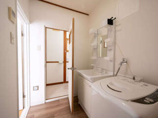 This charming property boasts a clean and efficient laundry area, complete with a modern washing machine and a stylish vanity sink.