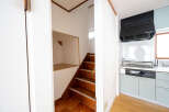 Cozy house with wooden stairs leading to an upper level, featuring a built-in storage space under the stairs.