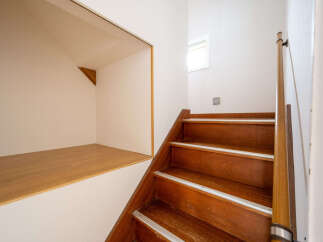 Discover this charming home featuring a unique built-in wooden bench nestled beneath the staircase, perfect for extra seating or storage.