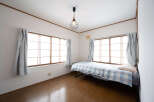 Cozy bedroom with hardwood floors and large windows offering plenty of natural light.