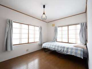 Cozy bedroom with hardwood floors and large windows offering plenty of natural light.