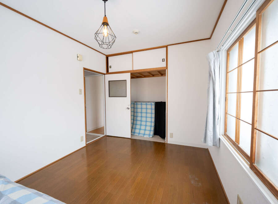 Bright and airy bedroom with hardwood floors and large windows.