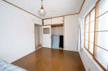 Bright and airy bedroom with hardwood floors and large windows.