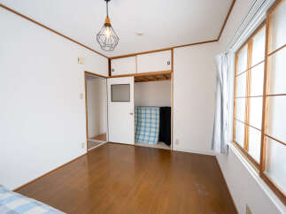 Bright and airy bedroom with hardwood floors and large windows.