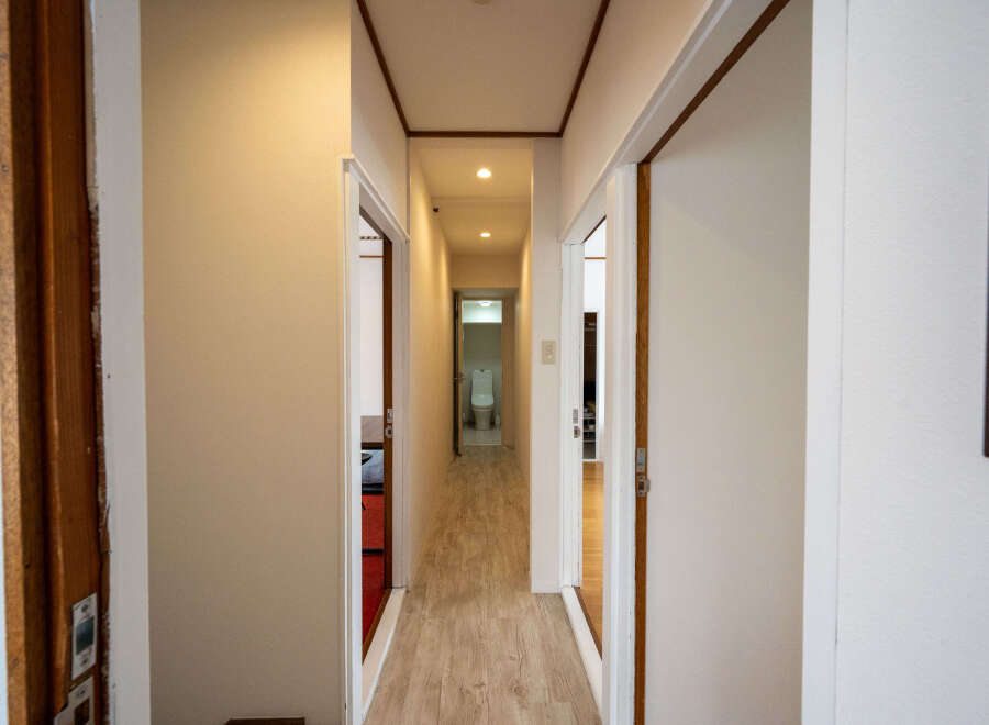 This hallway features light walls and wood-look flooring, creating a bright and airy atmosphere.