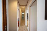 This hallway features light walls and wood-look flooring, creating a bright and airy atmosphere.