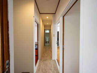 This hallway features light walls and wood-look flooring, creating a bright and airy atmosphere.