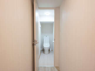 Modern and clean bathroom with a toilet and light wood walls.