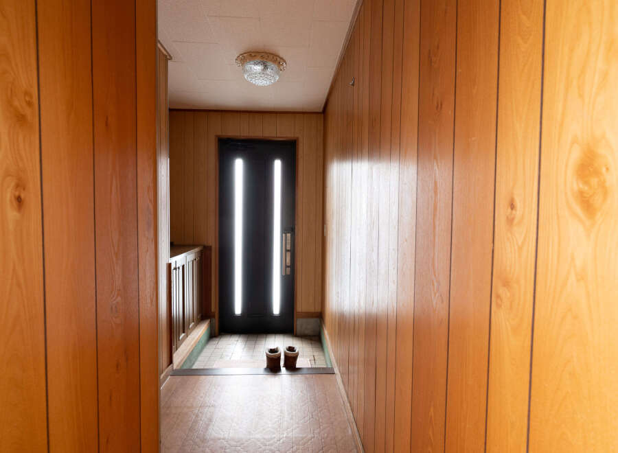 Step inside this charming home featuring a welcoming entryway with wood paneling and a tiled floor.