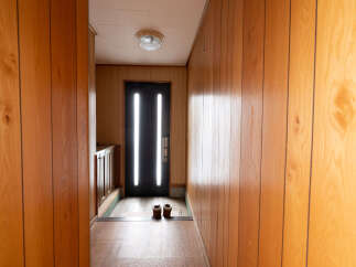 Step inside this charming home featuring a welcoming entryway with wood paneling and a tiled floor.
