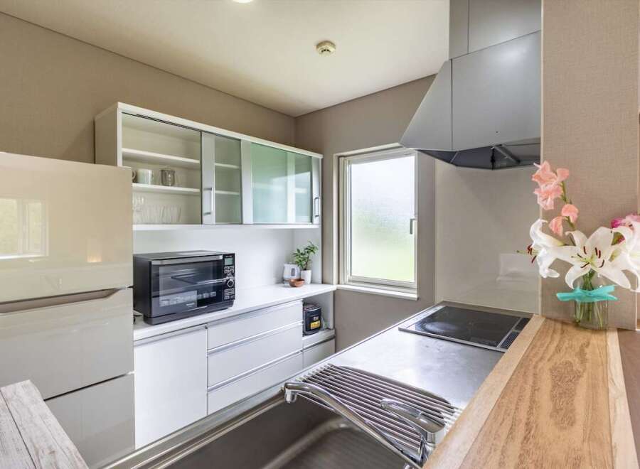 Modern kitchen with sleek white cabinets and stainless steel appliances.