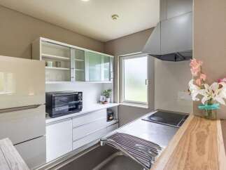 Modern kitchen with sleek white cabinets and stainless steel appliances.