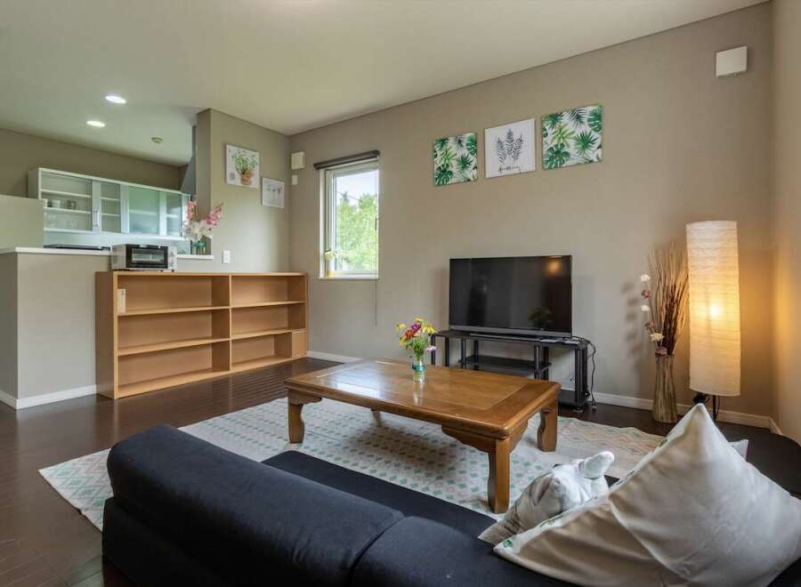 Cozy living room with a comfortable couch, coffee table, and flat-screen TV.