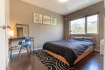 This cozy bedroom features a comfortable double bed, a convenient workspace with a desk and chair, and stunning mountain views from the large window.