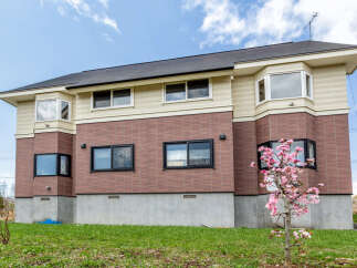 This stunning house boasts a modern design with a combination of brick and siding, creating a beautiful aesthetic.