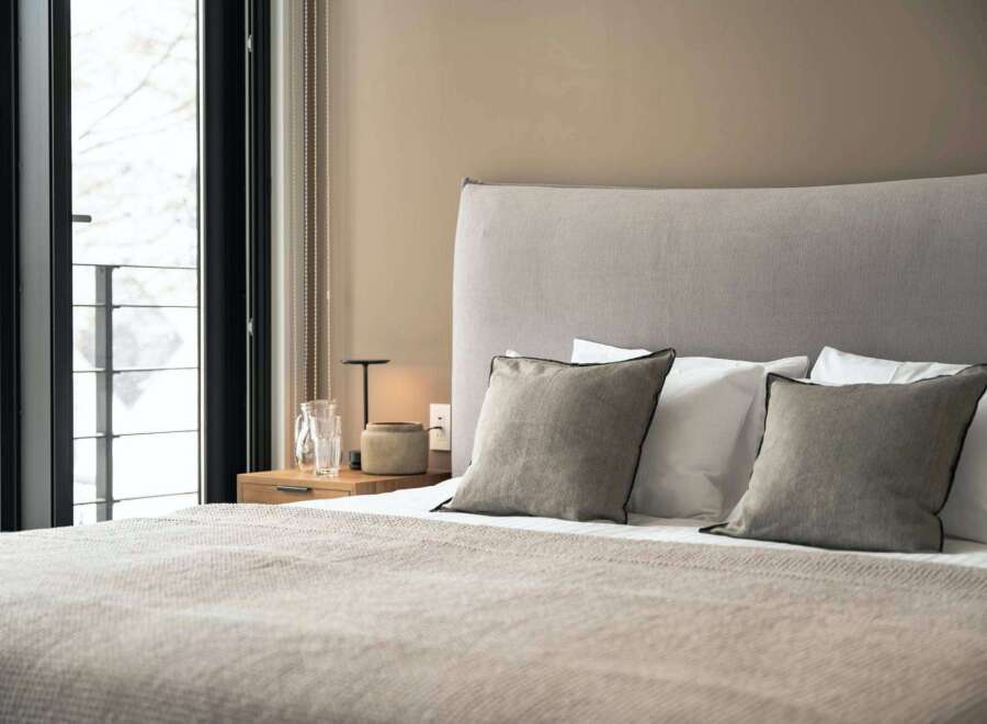 Wake up to breathtaking views from this cozy bedroom, featuring a plush bed and soft linens.