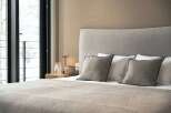 Wake up to breathtaking views from this cozy bedroom, featuring a plush bed and soft linens.