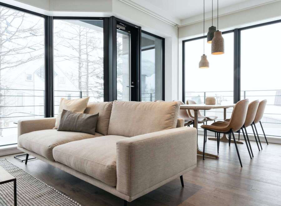 Modern apartment with floor-to-ceiling windows offering stunning snowy views.