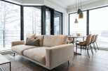 Modern apartment with floor-to-ceiling windows offering stunning snowy views.