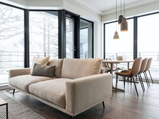 Modern apartment with floor-to-ceiling windows offering stunning snowy views.
