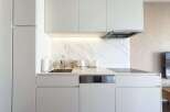Modern kitchen with white cabinets and marble backsplash.