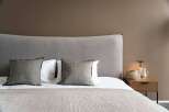 Wake up refreshed in our cozy bedroom, featuring a plush gray headboard and soft linens.