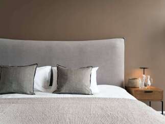 Wake up refreshed in our cozy bedroom, featuring a plush gray headboard and soft linens.