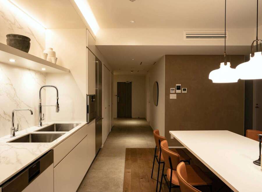 This stunning apartment boasts a modern kitchen with sleek white cabinetry, marble countertops, and high-end fixtures.