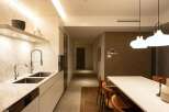 This stunning apartment boasts a modern kitchen with sleek white cabinetry, marble countertops, and high-end fixtures.