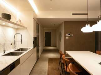 This stunning apartment boasts a modern kitchen with sleek white cabinetry, marble countertops, and high-end fixtures.