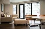 Modern living space with floor-to-ceiling windows offering stunning city views.