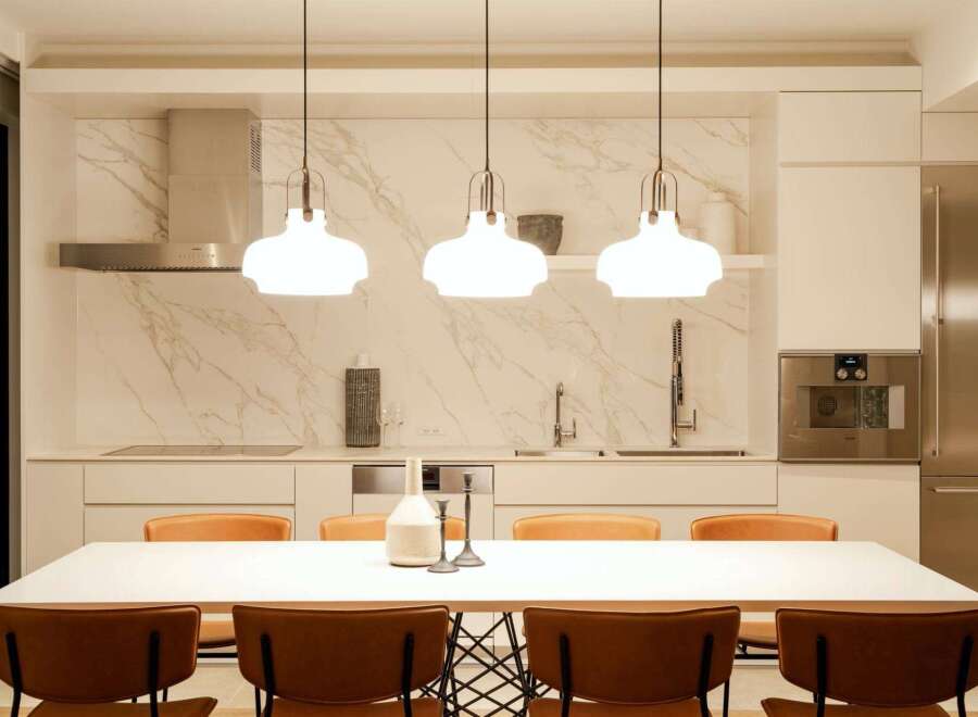 This stunning kitchen boasts a sleek design with marble backsplash and high-end stainless steel appliances.