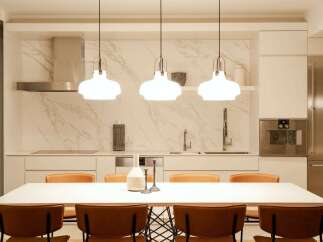 This stunning kitchen boasts a sleek design with marble backsplash and high-end stainless steel appliances.