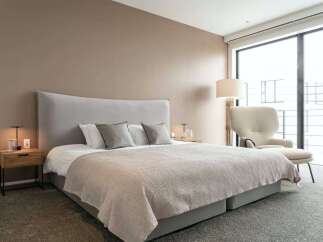 Luxurious bedroom with a king-size bed, plush carpet, and large windows offering stunning views.