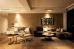 Modern living room with a neutral color palette, featuring a comfortable sectional sofa and a stylish armchair.