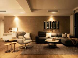 Modern living room with a neutral color palette, featuring a comfortable sectional sofa and a stylish armchair.