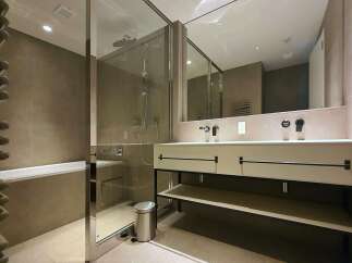 Modern bathroom with a glass shower enclosure, double vanity, and freestanding bathtub.