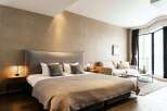 This stunning bedroom boasts a plush king-size bed, a cozy sofa, and large windows offering ample natural light.