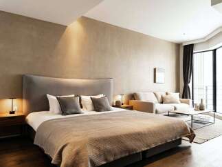 This stunning bedroom boasts a plush king-size bed, a cozy sofa, and large windows offering ample natural light.