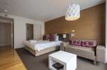 Modern hotel room featuring a comfortable king-size bed, stylish sofa, and a sleek coffee table.