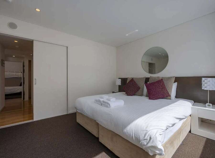 This stunning bedroom boasts a king-size bed, plush pillows, and ample natural light.