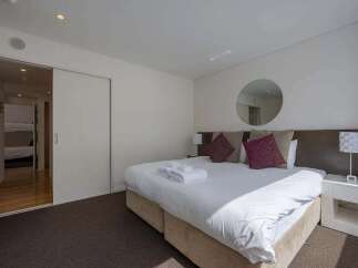This stunning bedroom boasts a king-size bed, plush pillows, and ample natural light.