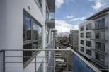 Modern apartment balcony overlooking mountain views and city.