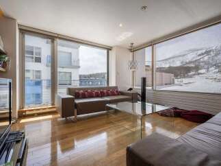 This stunning apartment boasts breathtaking views of snow-capped mountains and a modern, open-plan living area.