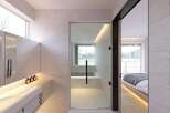 Modern bathroom with sleek design and floor-to-ceiling windows offering natural light.